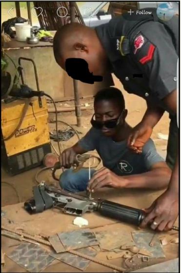 Nigerian Policeman Spotted Repairing His Gun at a Welder's Workshop (Photos)