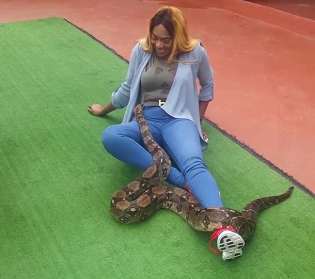 Unbelievable! Nigerian Actress Caught Playing with Lions and Romancing a Snake in South Africa (Videos)