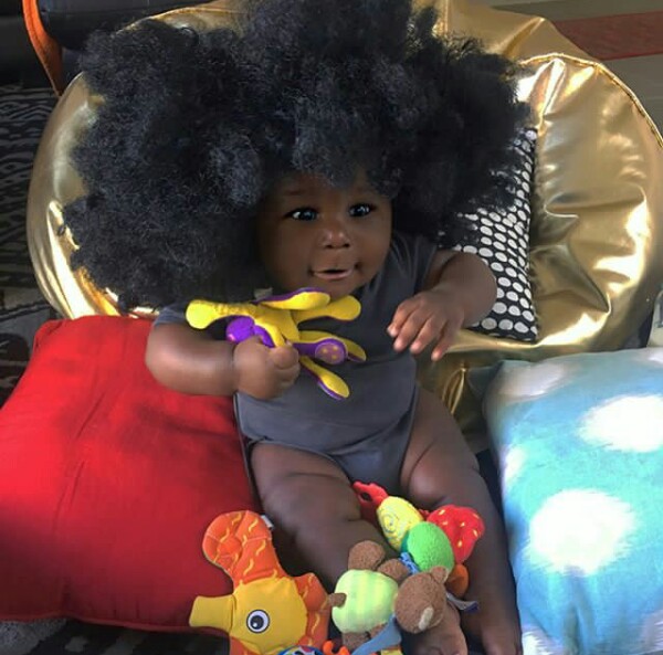 Young African mother celebrates her cute son with really beautiful black skin.