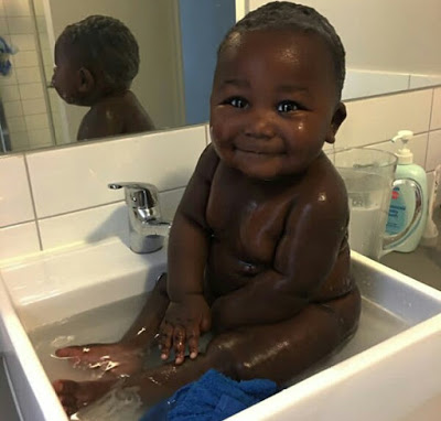 Young African mother celebrates her cute son with really beautiful black skin.