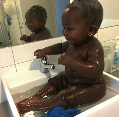 Young African mother celebrates her cute son with really beautiful black skin.