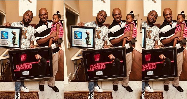 Davido, his daughter and Father pictured together as he shows off his musical achievement plaque
