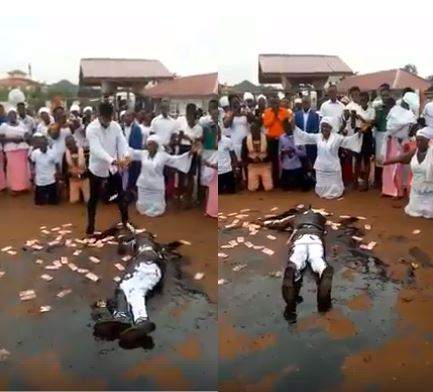 Drama as pastor rolls in engine oil while members spray money on him during crusade (video)