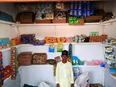 Primary school pupil poses in front of his 'Shopping Complex' in Kano