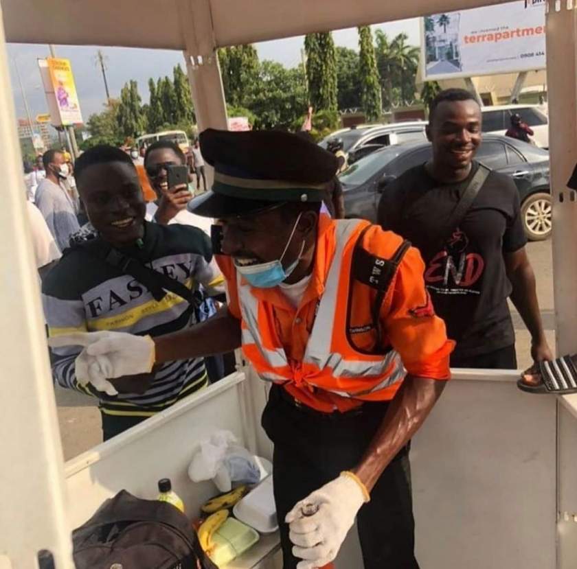 Traffic warden in tears as Abuja protesters shower him with food, drinks and cash to appreciate his good work (Photos/Video)
