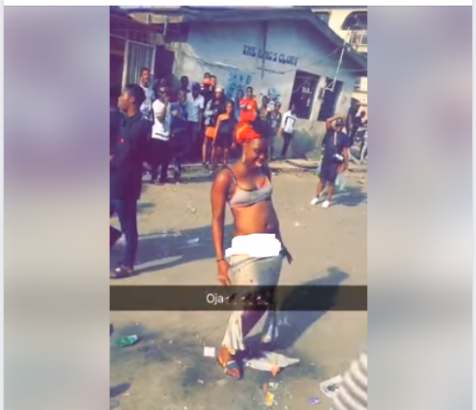 Lady strips off in the middle of a road in Mushin, Lagos (photos)