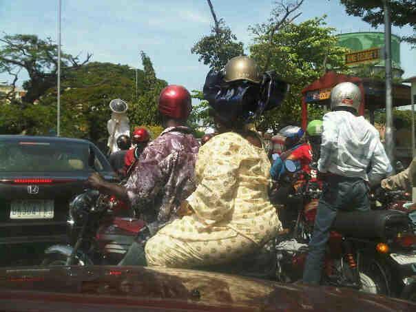 Photo Of A Yoruba Woman Wearing Helmet On Her Large Igele Head Scarf