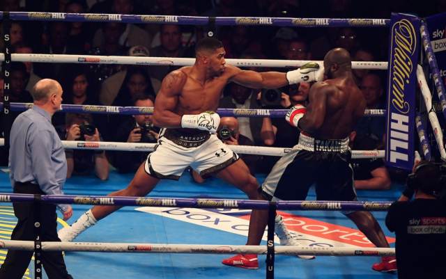 Anthony Joshua beats Carlos Takam by TKO to retain world heavyweight titles.