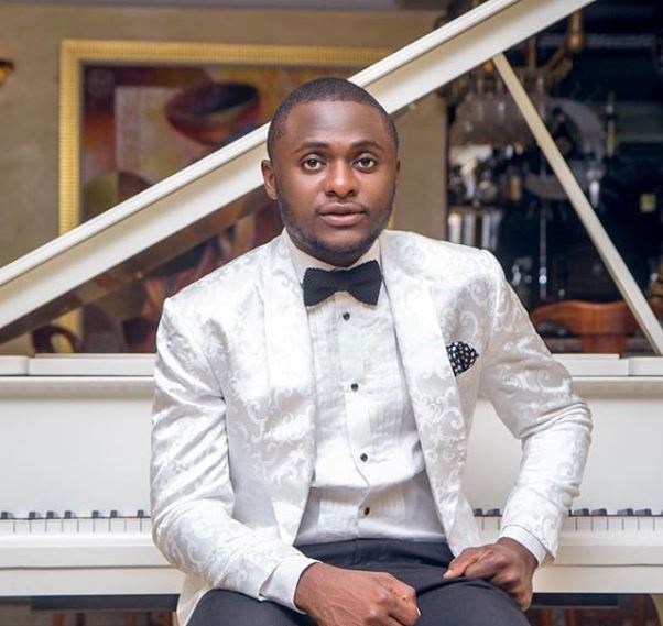 "Fire Burn You" - Ubi Franklin Replies Follower Who Faulted Photo Of His Son Strapped To His Back