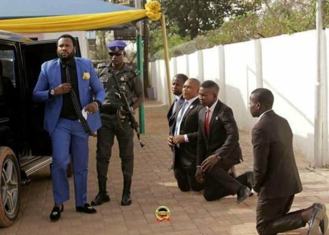 Grown Men Kneel Down To Welcome Their Pastor As He Steps Out From His Car In Abuja.