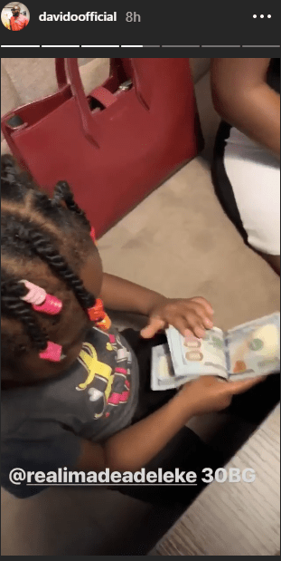 Davido's daughter, Imade plays with bundle of $100 bills