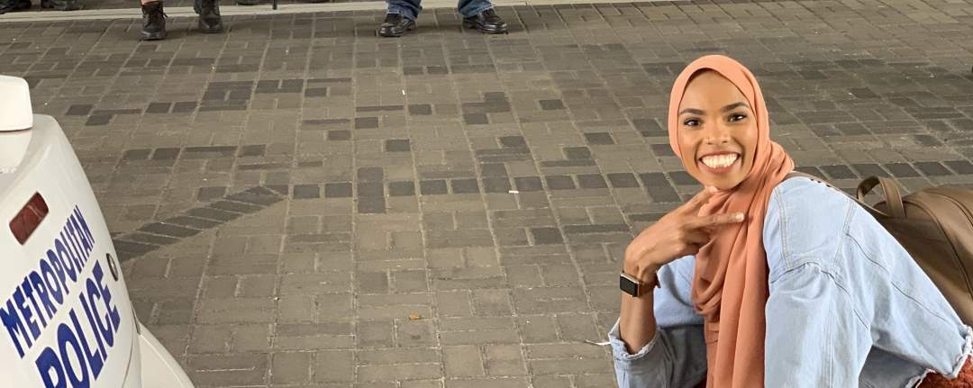 Muslim woman goes viral as she defies anti-Muslim protesters by taking smiling photo in front of them