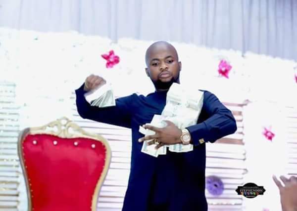 Trending photos of Anambra bulletproof Pastor, Elijah, flaunting bundles of naira before he was 'shot'.