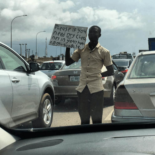 Man Pictured Advertising His Dry-Cleaning Service Inside Abuja Traffic